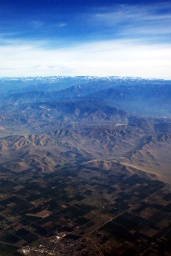 vorne Visalia mit der Sierra Nevada in der Mitte und den Rocky Mountains im Hintergrund